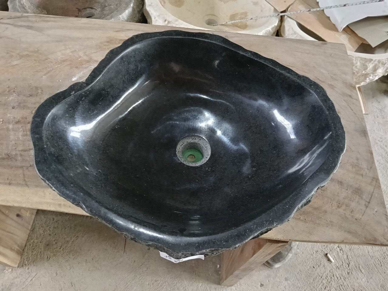 Top view of A100-5042 black andesite stone sink with polished interior and rough chiseled exterior, organic irregular shape.

