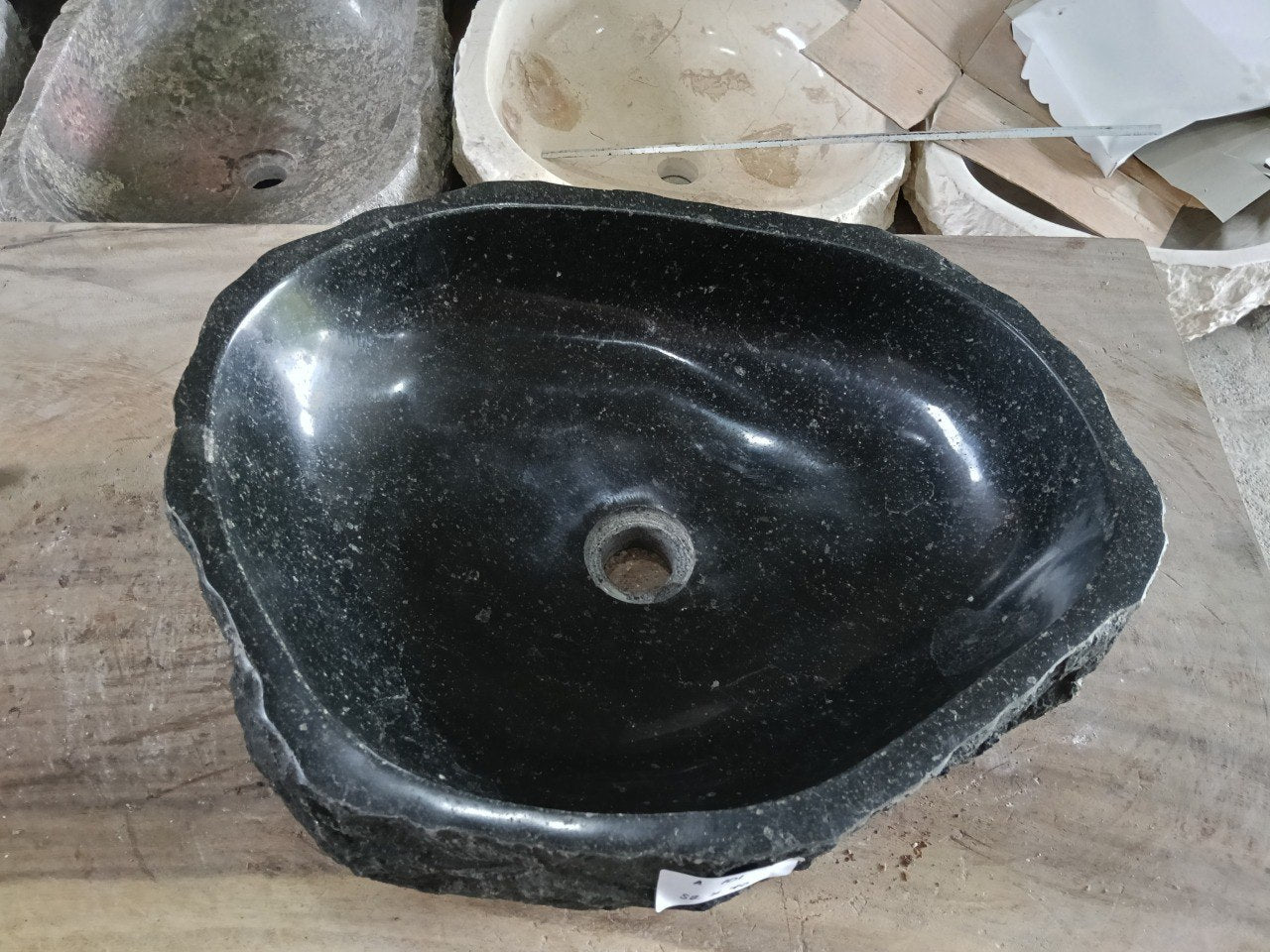 Top view of A101-5240 black andesite stone sink with polished interior and rough chiseled exterior, triangular organic shape.

