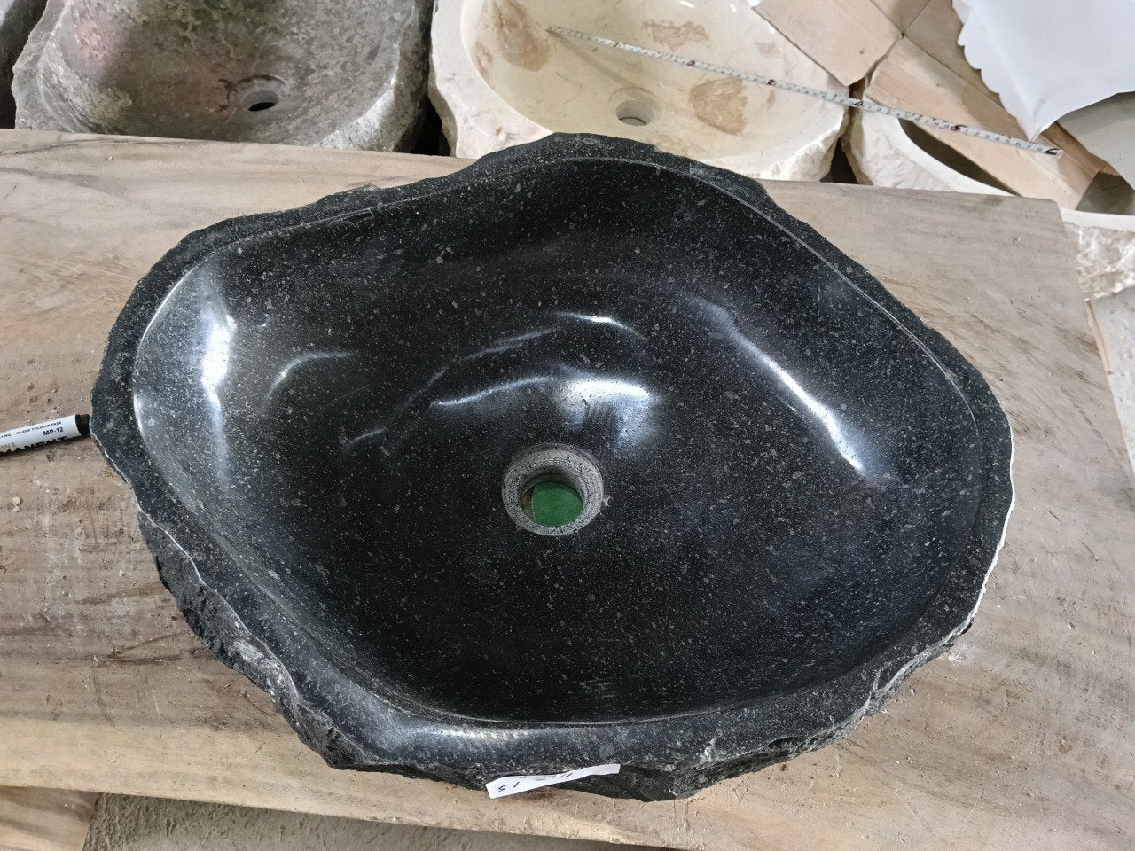 Top view of A102-5141 black andesite stone sink with polished interior and rough chiseled exterior, organic irregular shape.
