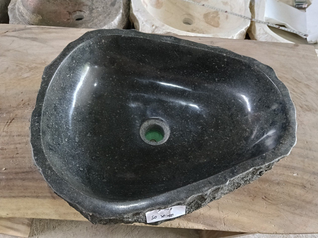 Top view of A107-5040 black andesite stone sink with polished interior and rough chiseled exterior, triangular organic shape.
