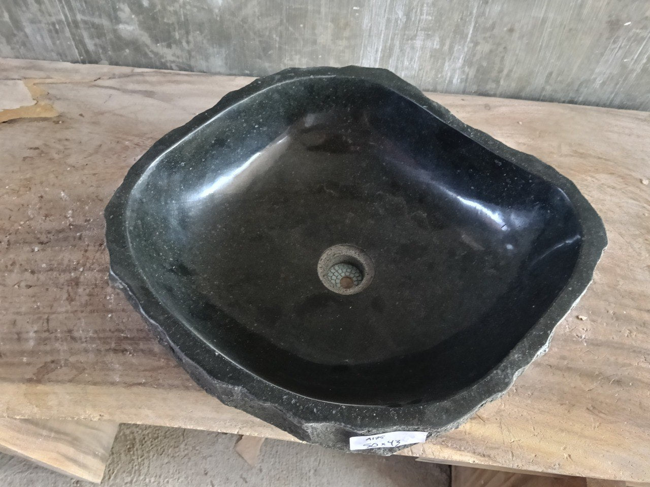 Top view of A175-5043 black andesite stone sink with polished interior and rough chiseled exterior, triangular organic shape.
