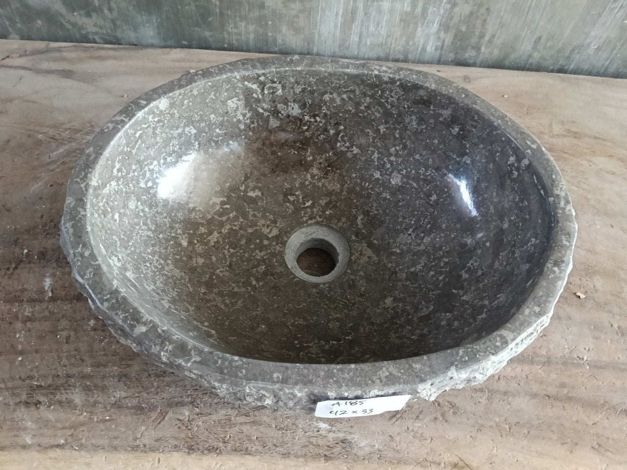 Top view of A185-4233 dark charcoal marble sink with polished interior and rough natural exterior, organic round-oval shape.
