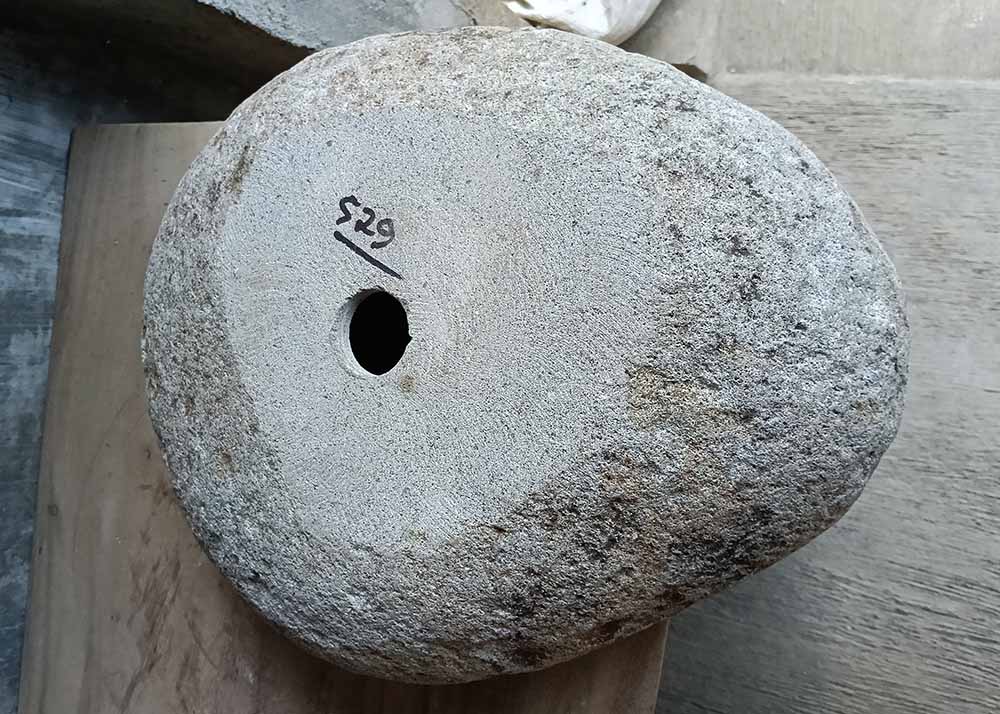 Bottom view of river stone sink showing natural unpolished base with felt pads and drain hole – SKU 6529-1815
