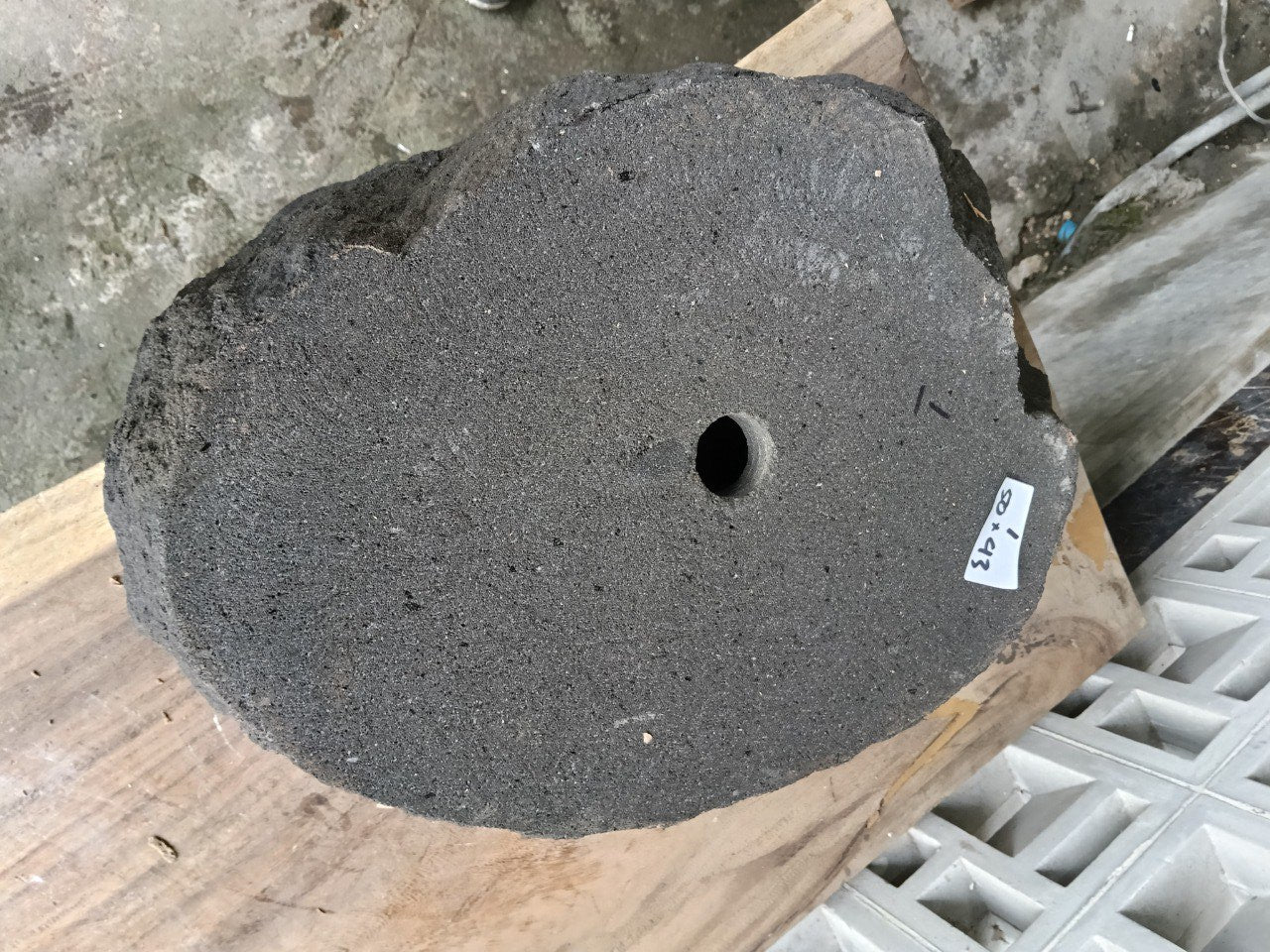 Bottom view of oval andesite stone sink with drain hole
