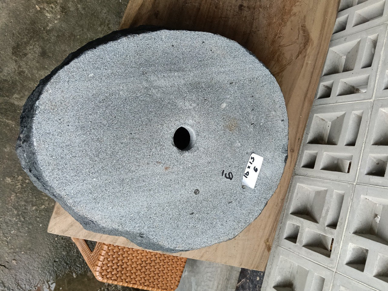 Bottom view of oval andesite stone sink with drain hole
