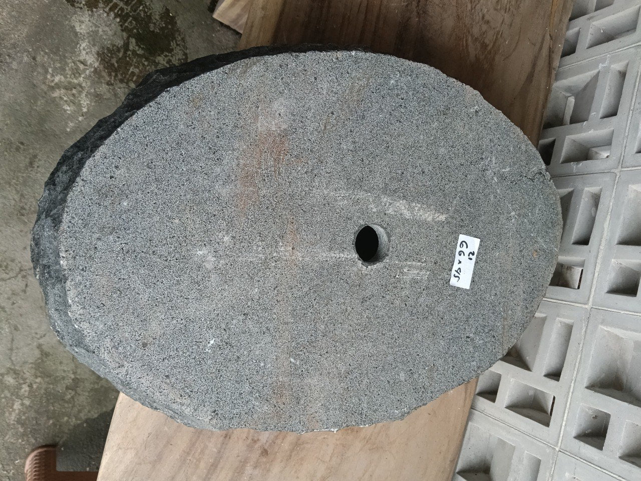 Bottom view of oval andesite stone sink with drain hole
