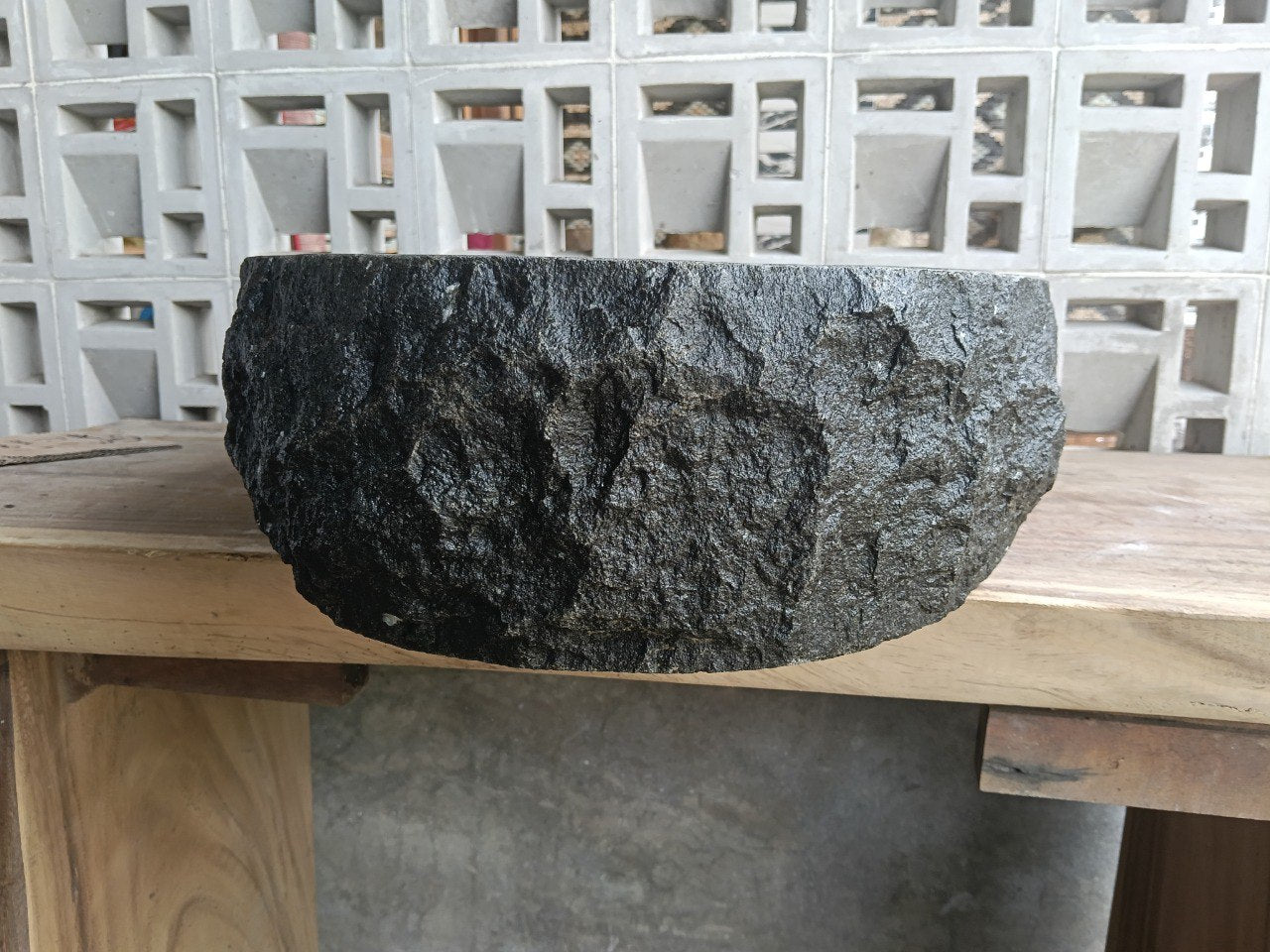 Right side perspective of handcrafted dark gray stone sink
