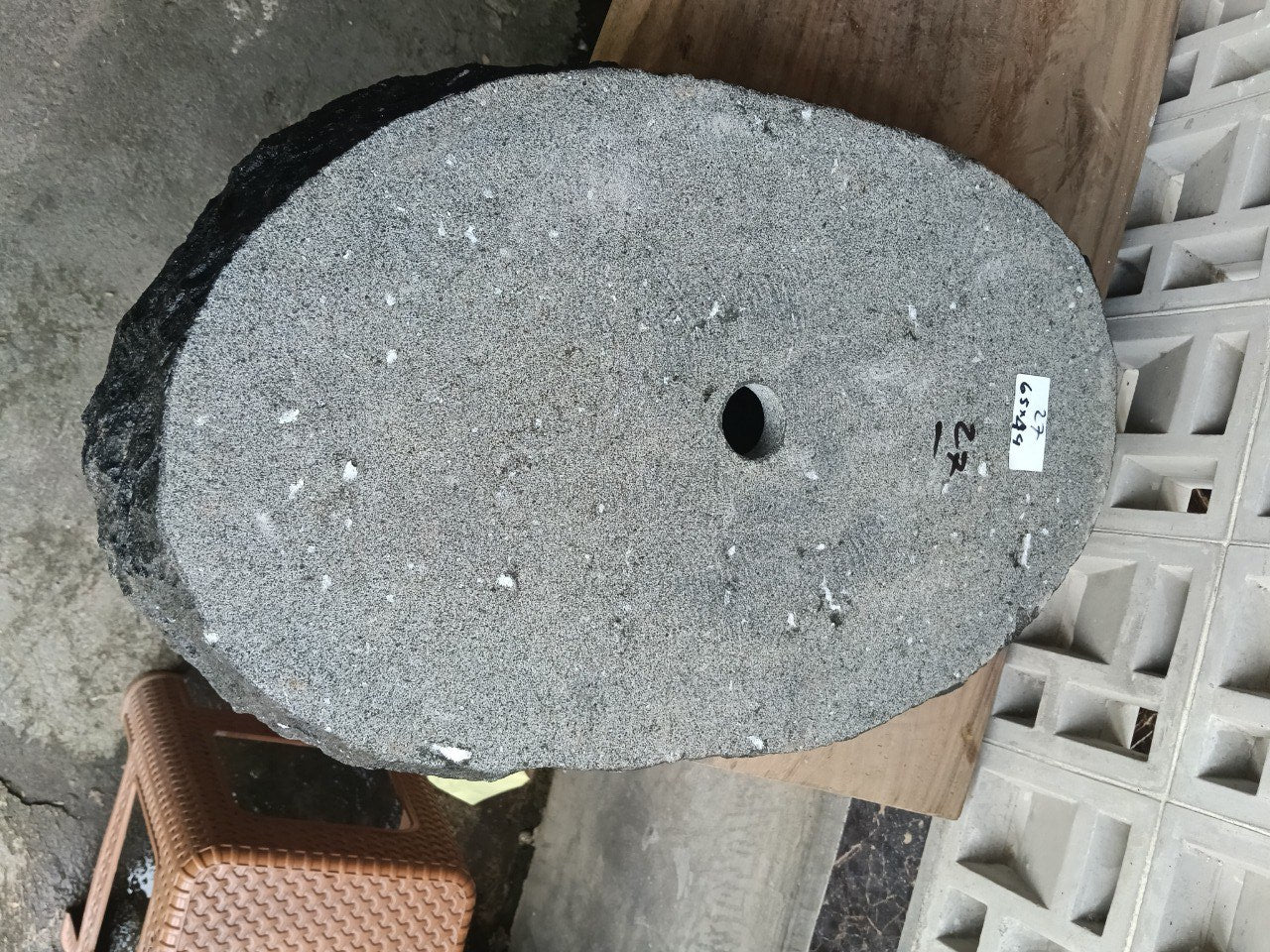 Bottom view of oval andesite stone sink with drain hole
