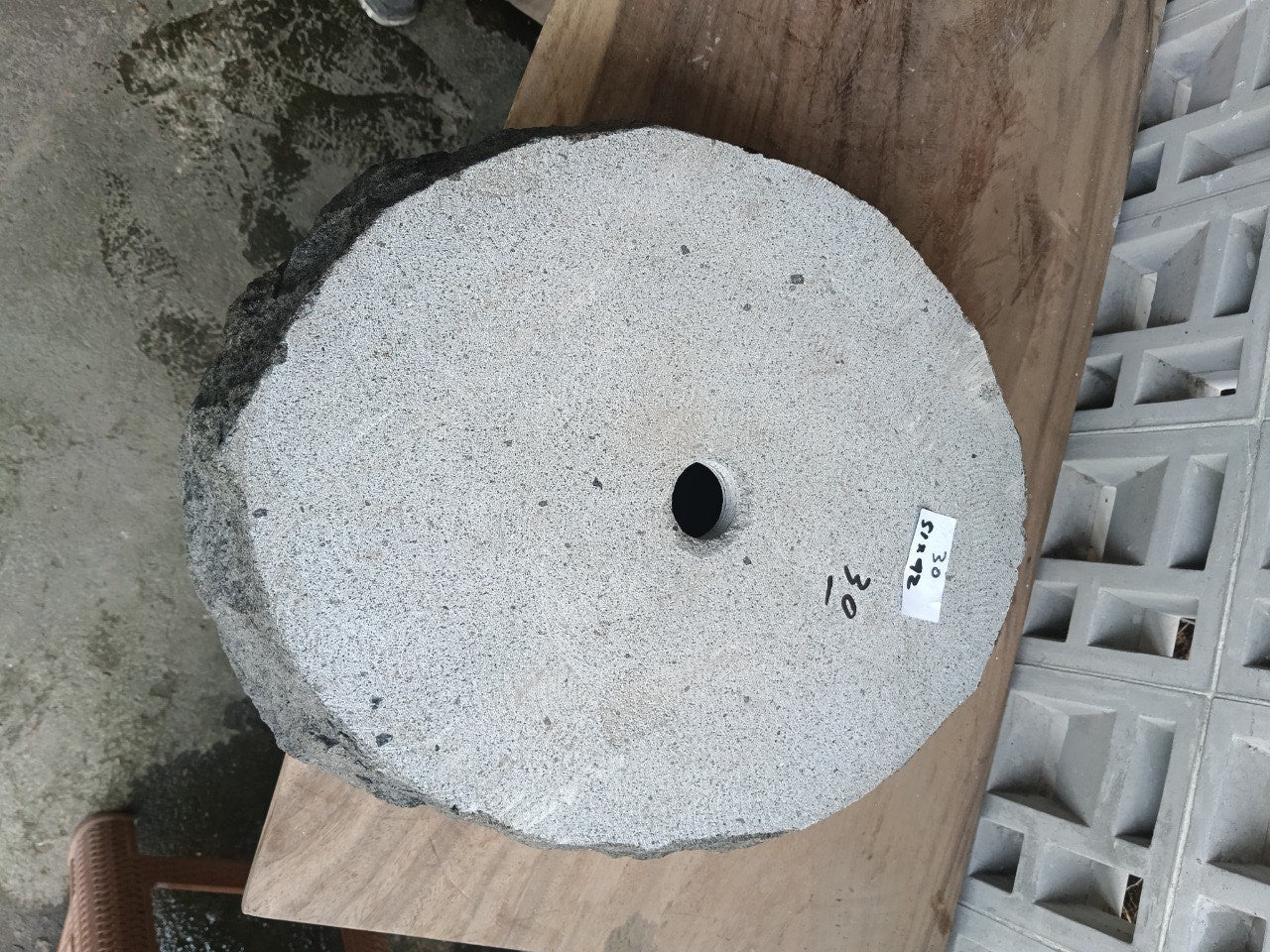 Bottom view of oval andesite stone sink with drain hole
