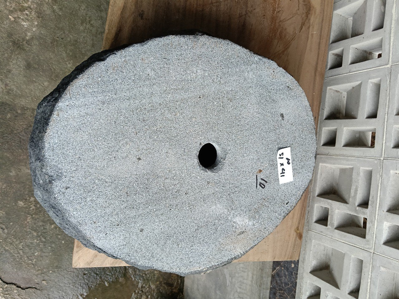 Bottom view of oval andesite stone sink with drain hole
