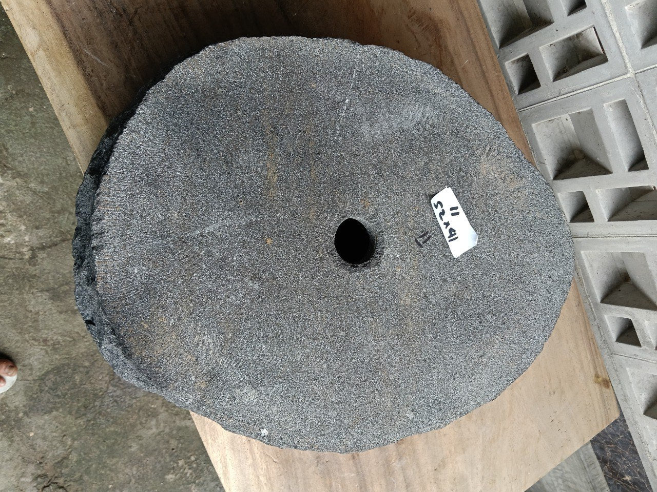 Bottom view of oval andesite stone sink with drain hole
