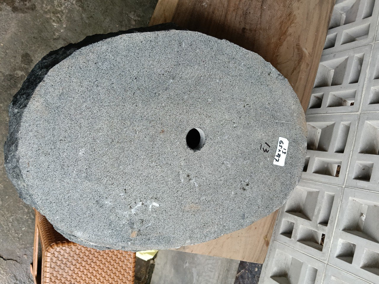 Bottom view of oval andesite stone sink with drain hole
