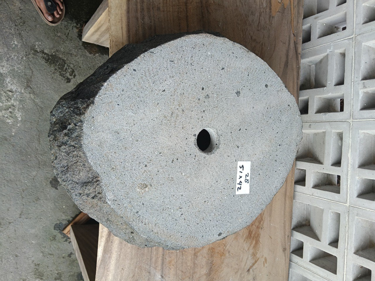 Bottom view of oval andesite stone sink with drain hole
