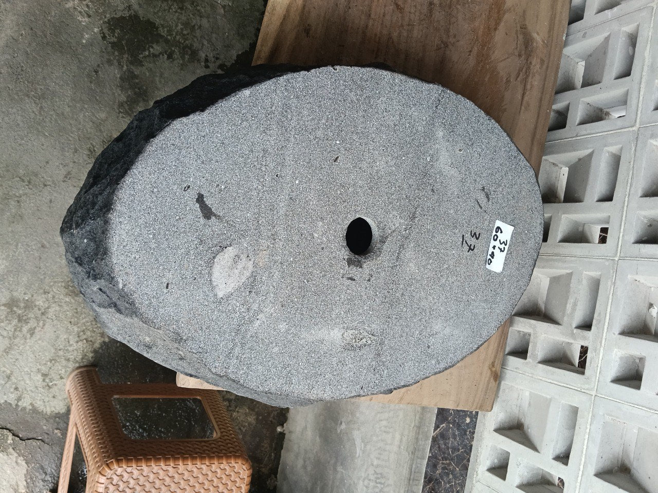 Bottom view of oval andesite stone sink with drain hole
