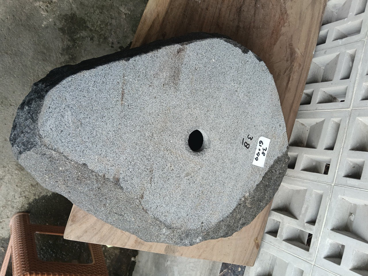 Bottom view of asymmetrical andesite stone sink with drain hole
