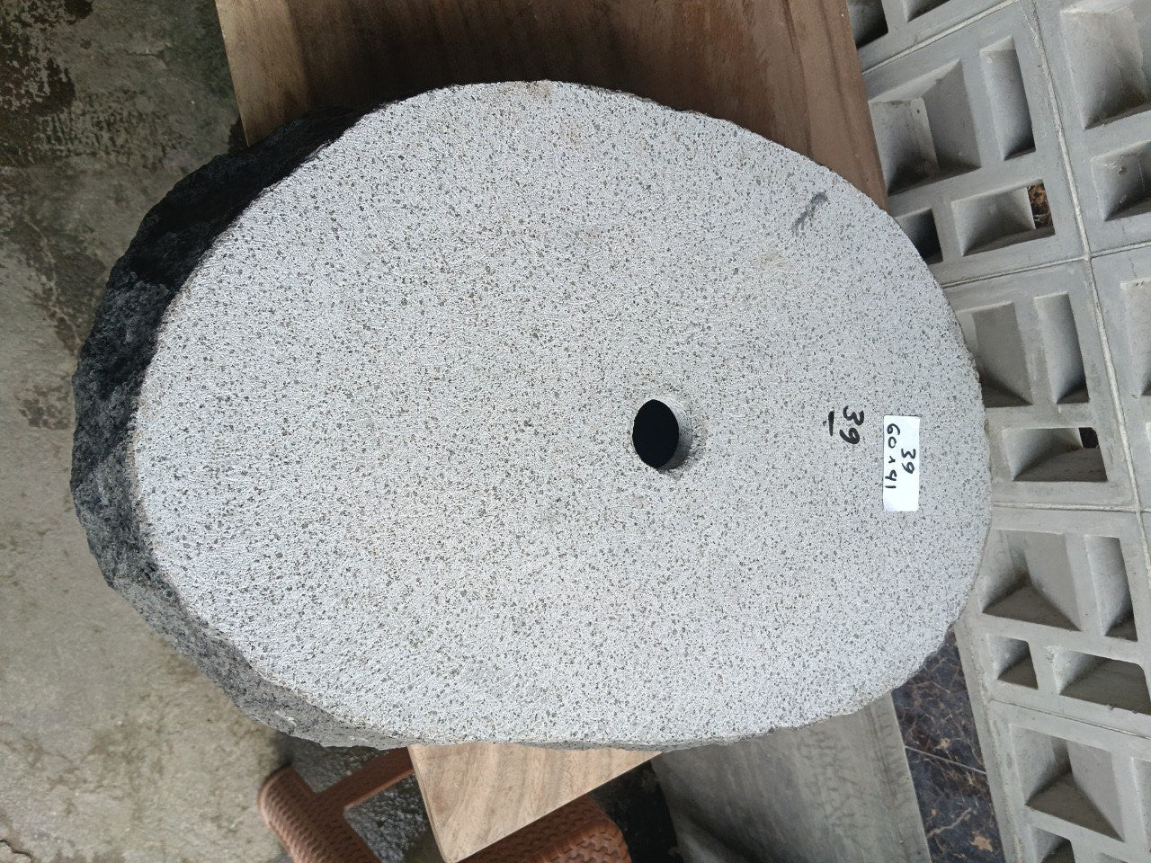 Bottom view of oval andesite stone sink with drain hole
