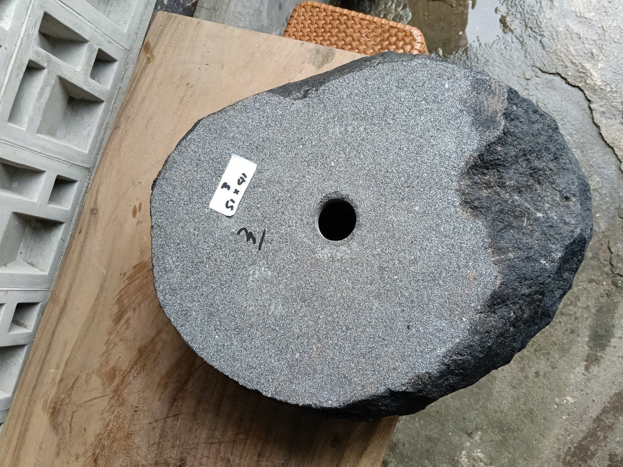 Bottom view of oval andesite stone sink with drain hole
