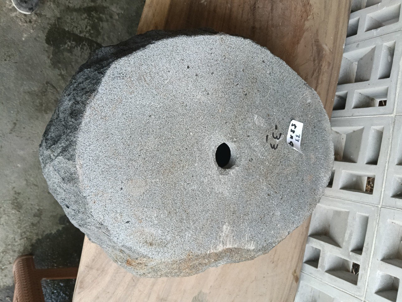 Bottom view of oval andesite stone sink with drain hole
