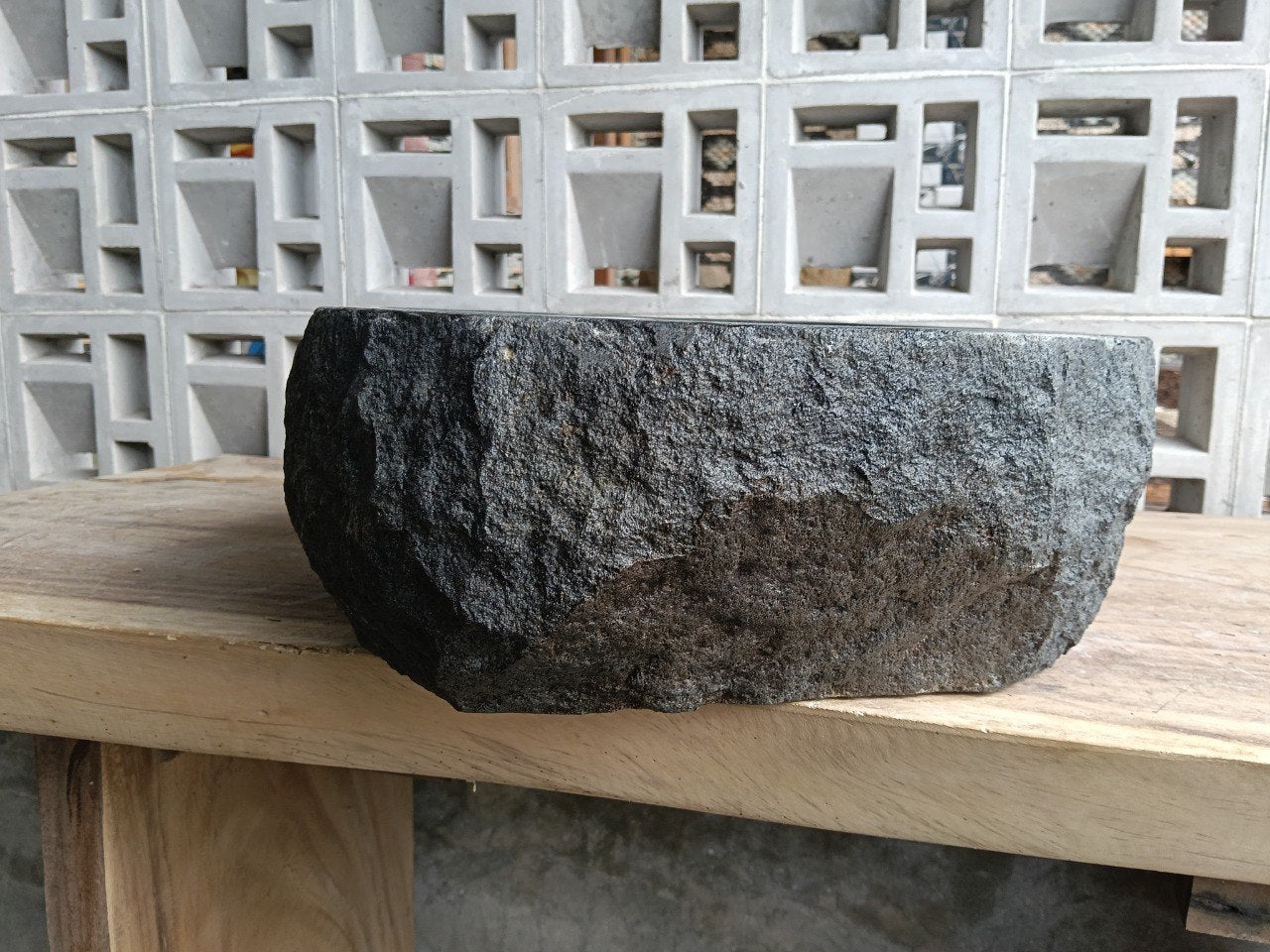 Left side perspective of oval andesite basin with polished interior
