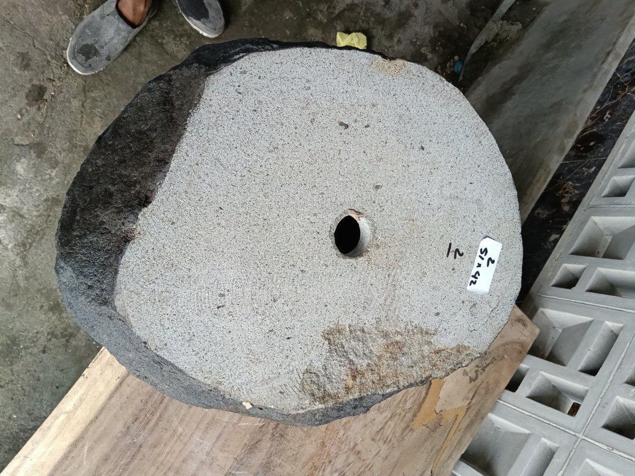 Bottom view of oval andesite stone sink with drain hole
