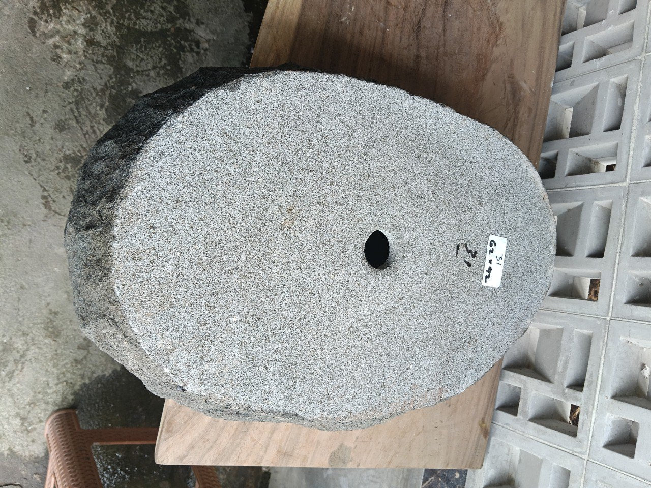 Bottom view of elongated oval andesite stone sink with drain hole
