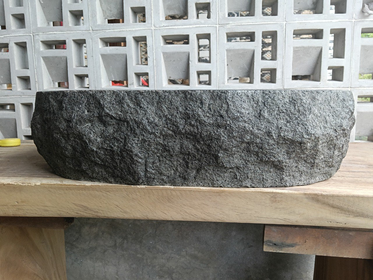 Left side perspective of oval andesite basin with polished interior

