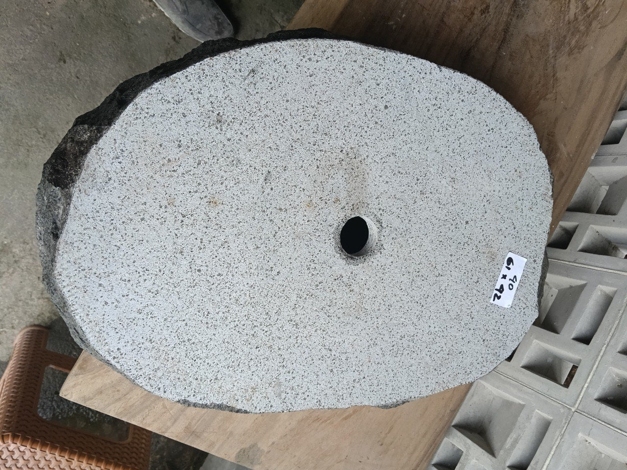 Bottom view of elongated oval andesite stone sink with drain hole
