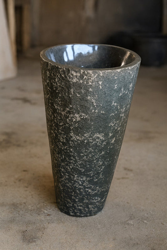 Front view of gray andesite pedestal sink with textured exterior

