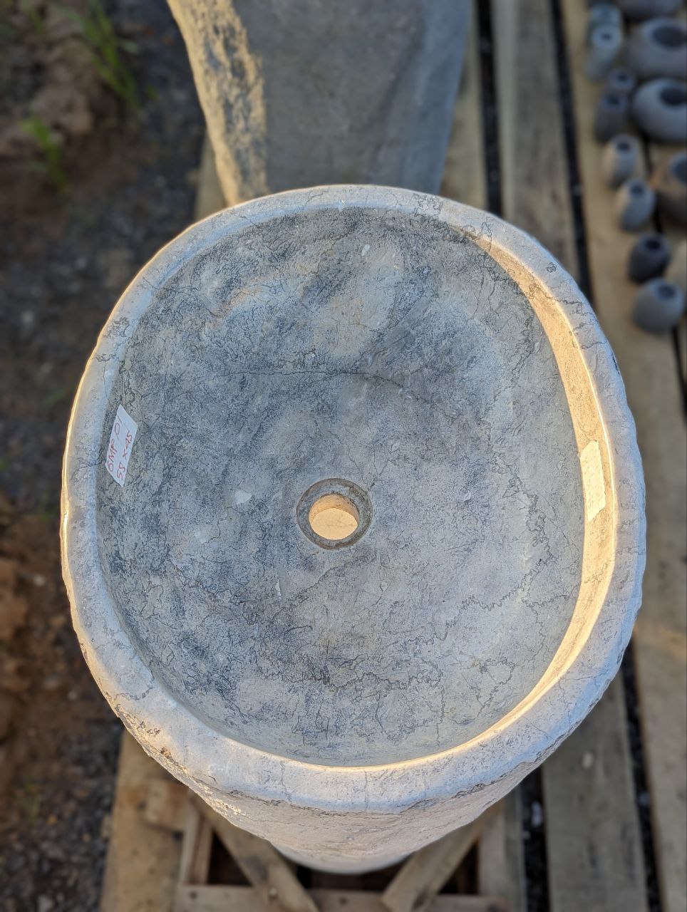 Polished interior of marble pedestal sink with rough exterior
