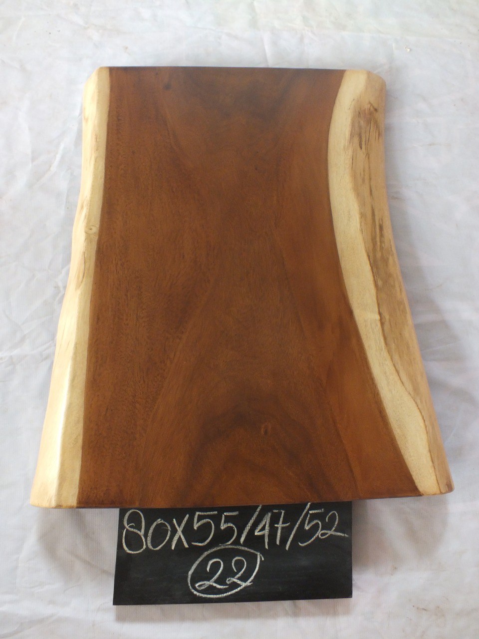 Top view of suar wood slab 0022-554752 with live edge shape and warm brown natural wood grain, organic tapered single-piece countertop.
