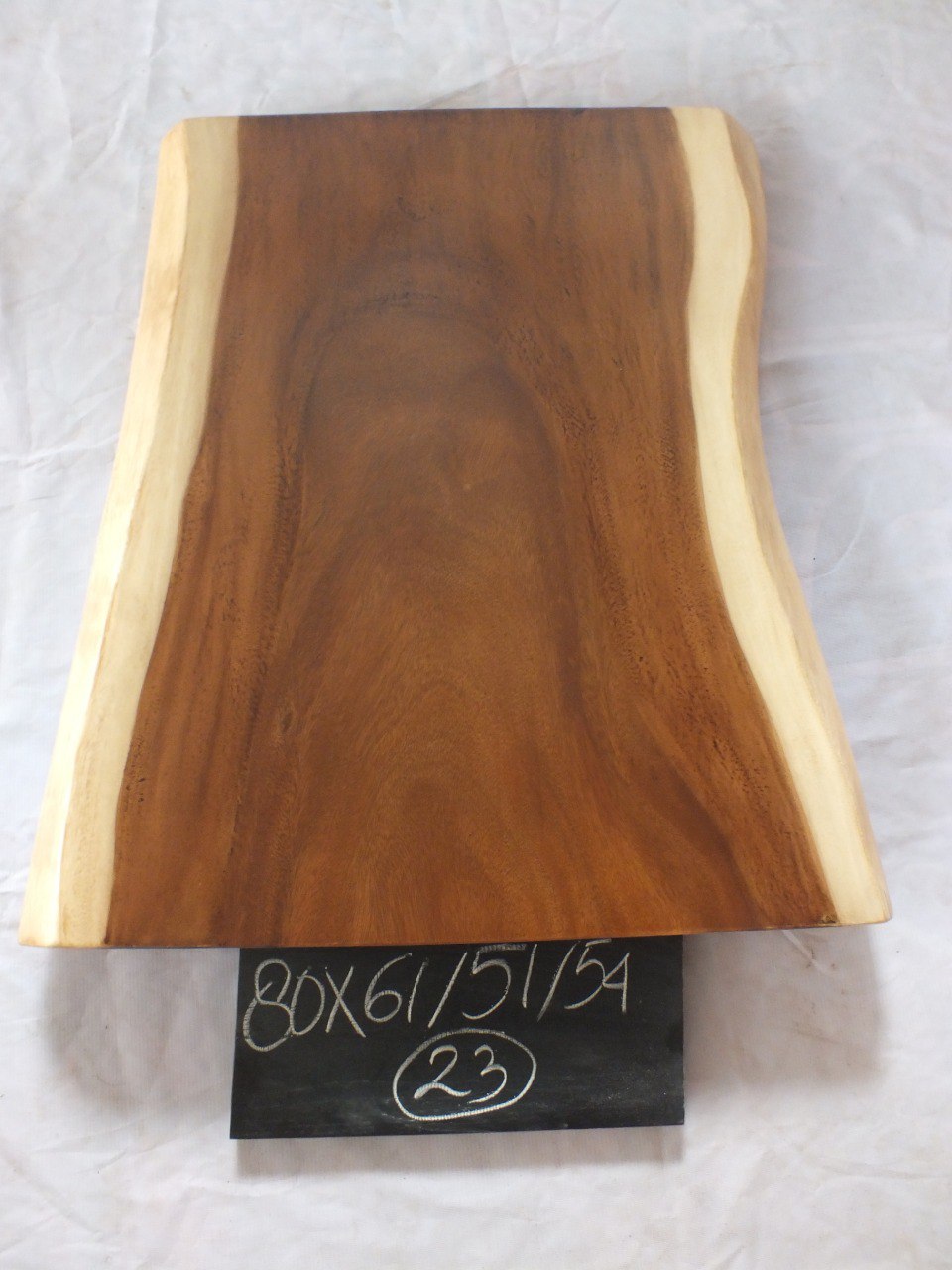 Top view of suar wood slab 0023-615154 with live edge shape and warm brown natural wood grain, organic tapered single-piece countertop.
