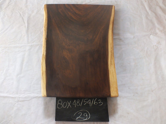 Top view of suar wood slab 0029-485463 with smooth widening live edge shape and rich brown natural wood grain, solid single-piece countertop.
