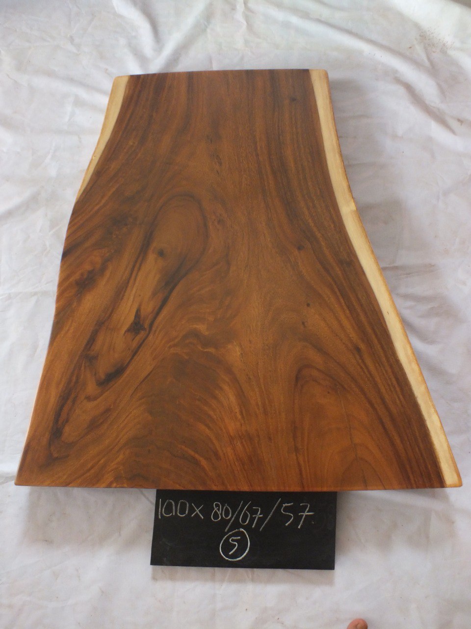 Top view of suar wood slab 0005-806757 with wide-to-narrow live edge shape and rich brown natural wood grain, solid single-piece countertop.
