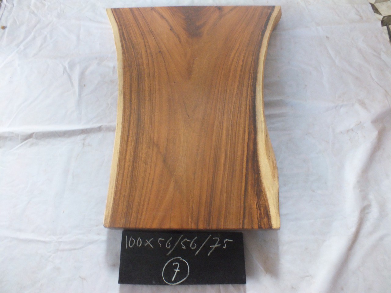 Top view of suar wood slab 0007-565675 with widening live edge shape and rich brown natural wood grain, solid single-piece countertop.
