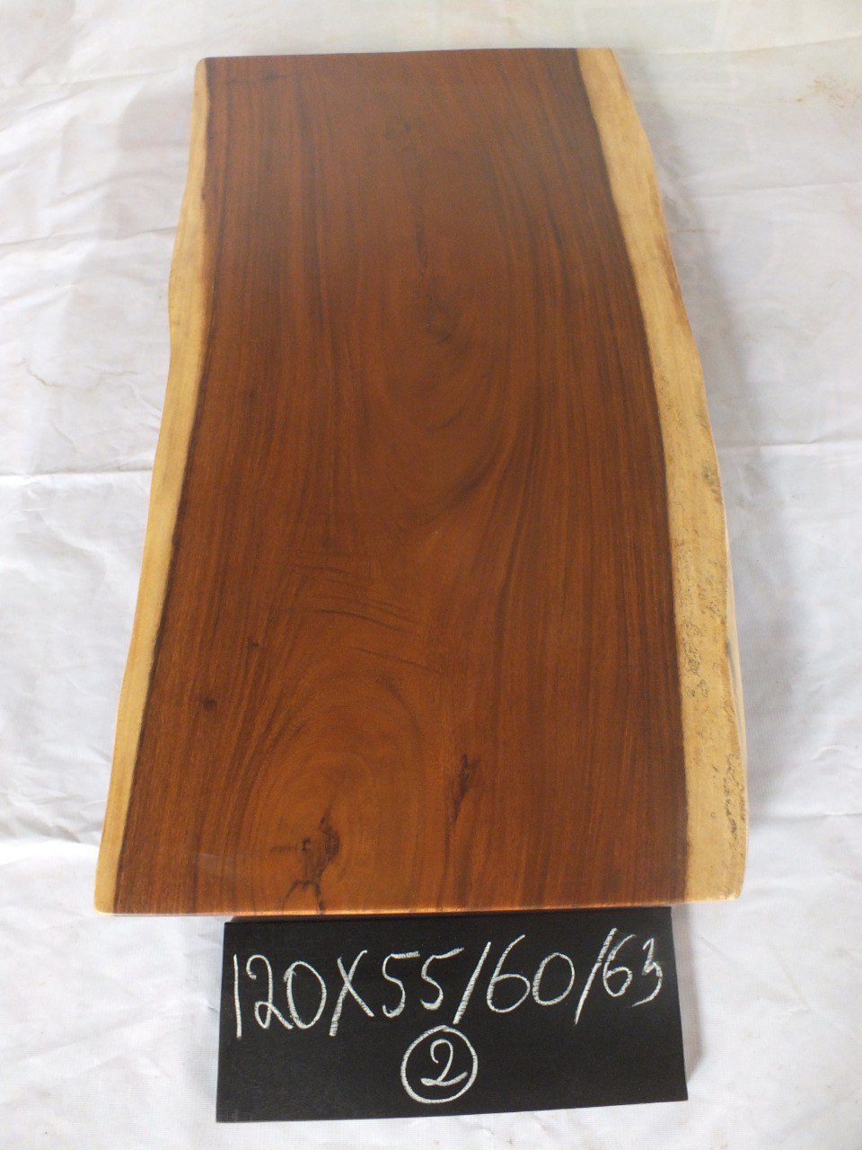 Top view of suar wood slab 0002-556063 with long live edge shape and warm brown natural wood grain, solid single-piece countertop.
