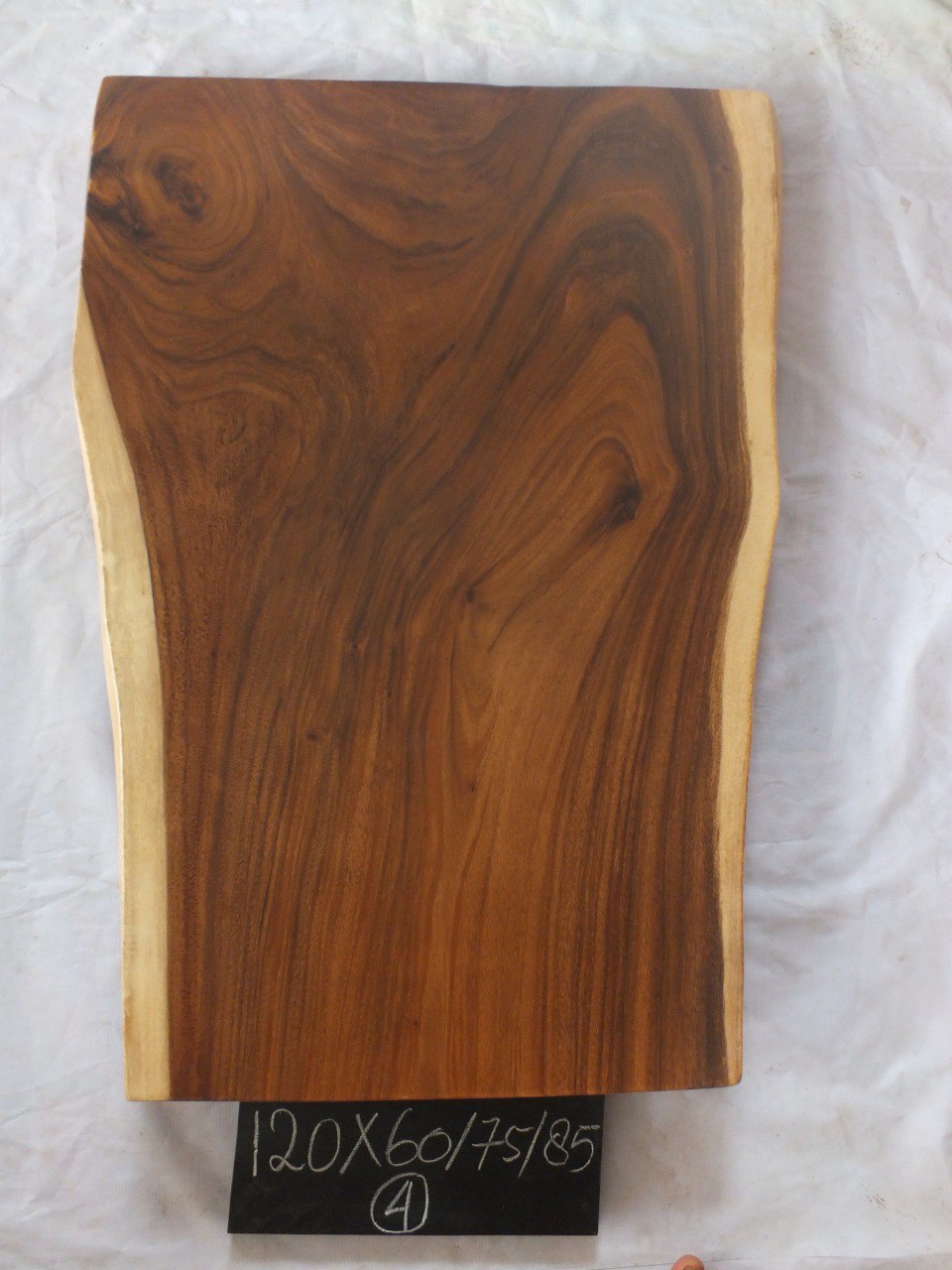 Top view of suar wood slab 0004-607585 with extra-wide widening live edge shape and rich brown natural wood grain, solid single-piece countertop.
