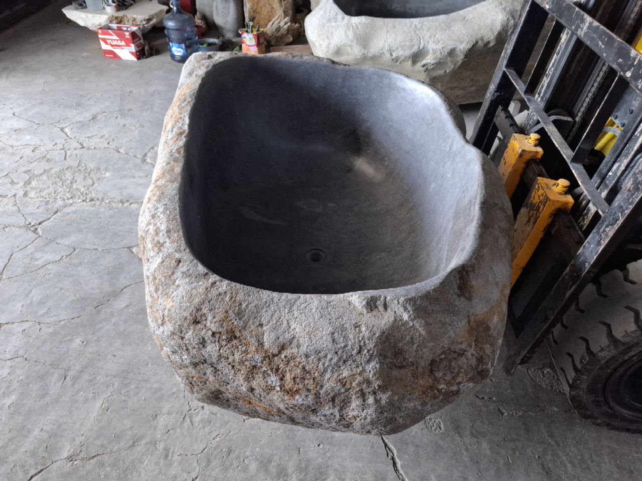 Close-up of polished interior surface of river stone tub
