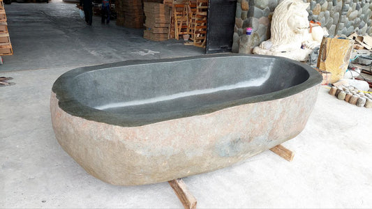Top view of oversized river stone bathtub with polished interior
