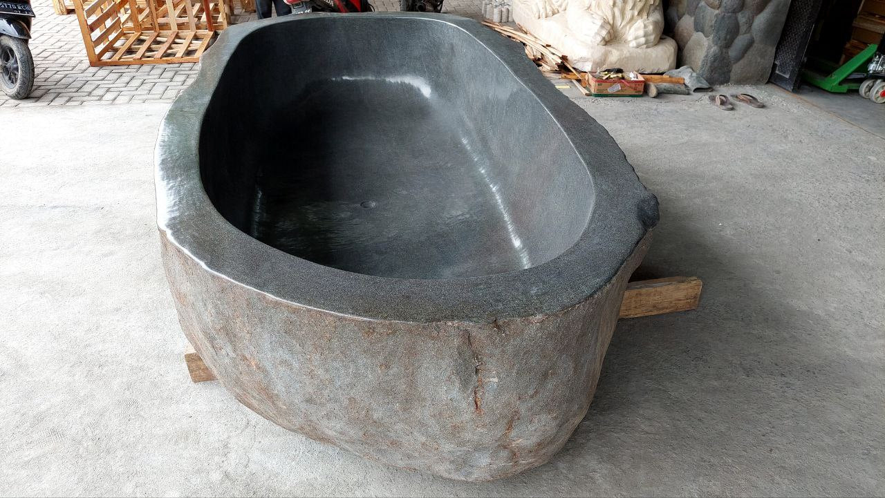 Close-up of polished interior surface of river stone bathtub
