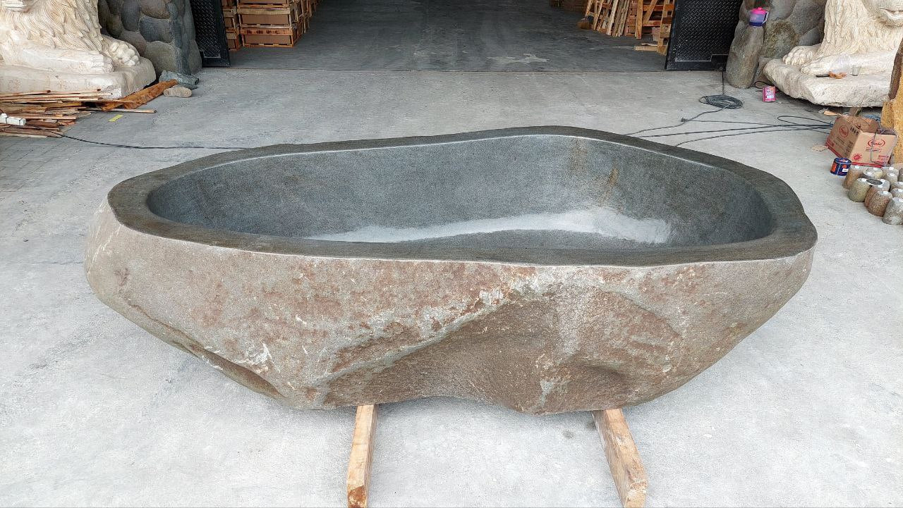 Organic shape river stone bathtub with natural exterior texture
