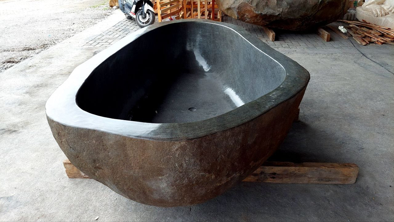 Close-up of polished interior surface of river stone bathtub
