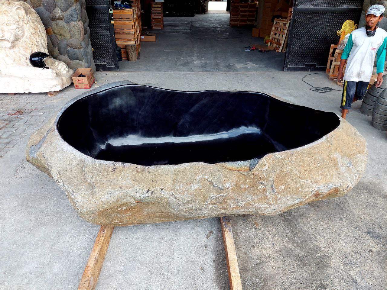 Side angle of river stone bathtub – polished interior, raw exterior