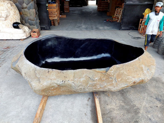 Side angle of river stone bathtub – polished interior, raw exterior