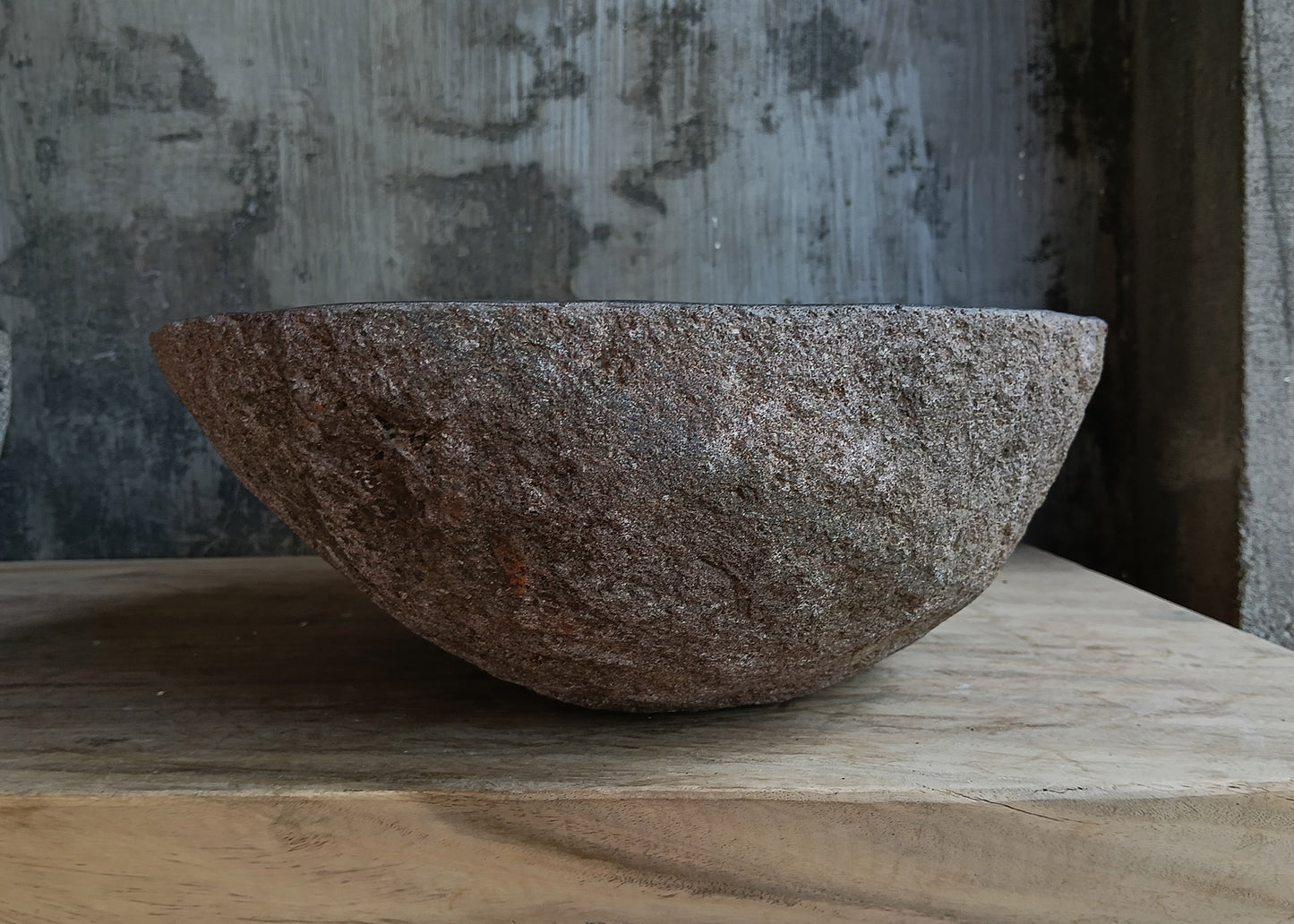 Left side view of dark brown oval river stone sink 6636-4638 with rough exterior
