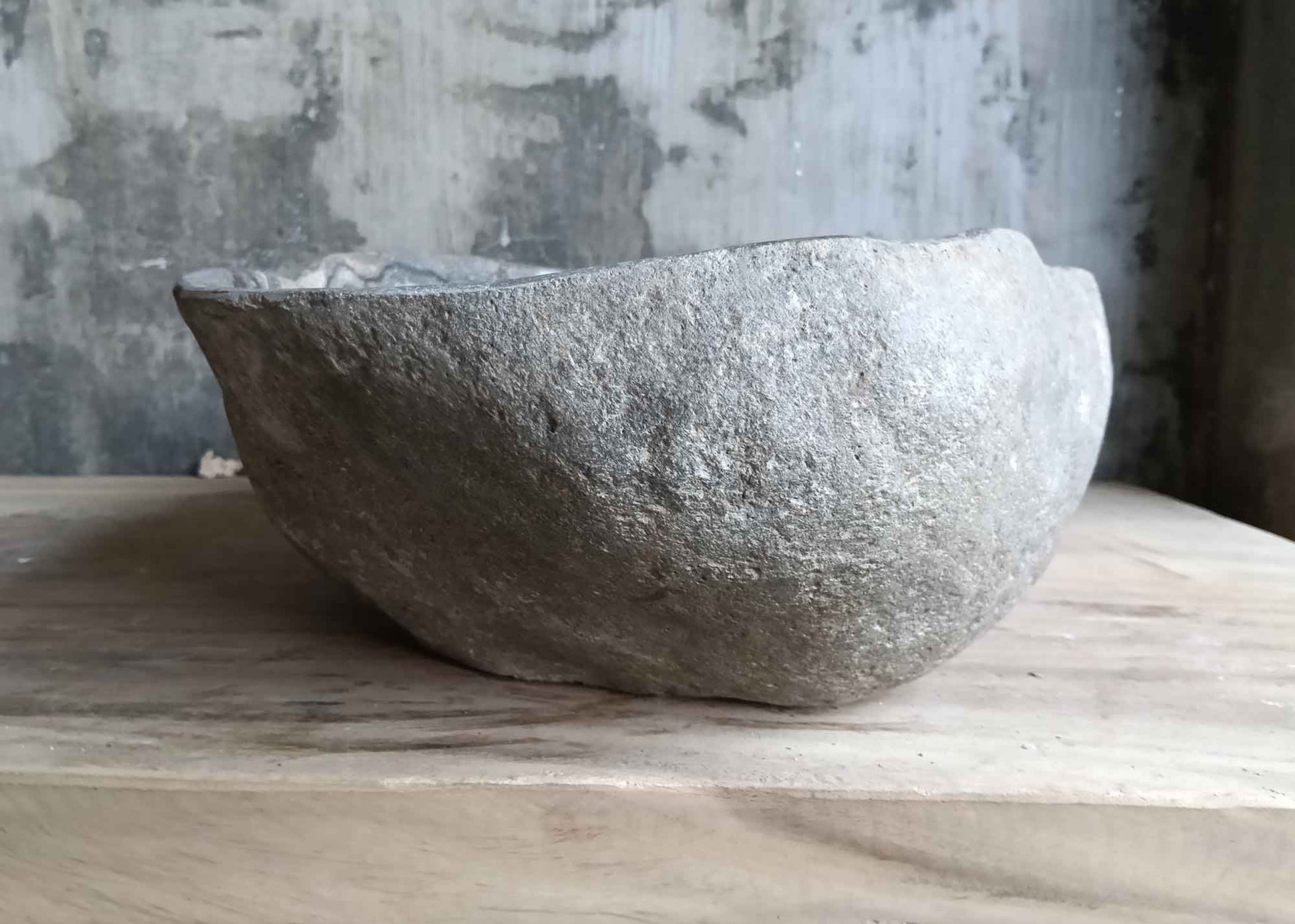 Right side view of mixed-tone river stone sink featuring rare mineral veins and raw exterior
