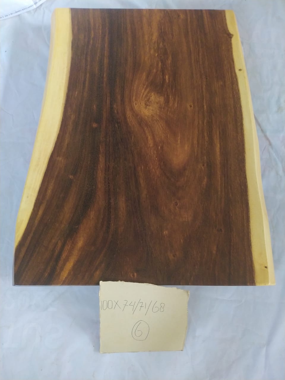Top view of suar wood slab 0006-747168 with wide live edge profile and rich flowing brown wood grain, solid single-piece countertop.
